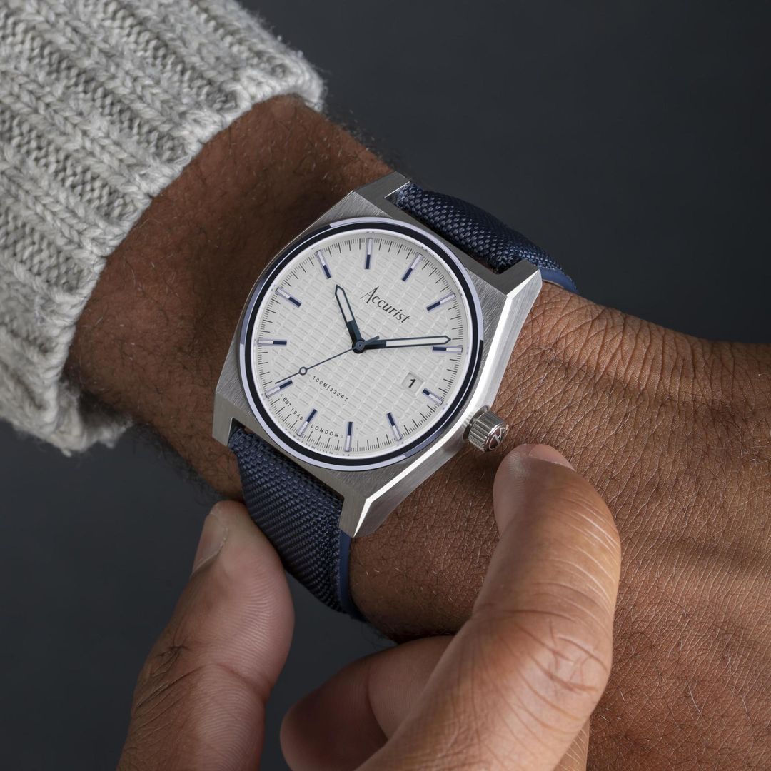 Zegarek męski Accurist z białą tarczą z datownikiem w stalowej kopercie o zaokrąglonym kształcie na materiałowym, granatowym pasku
