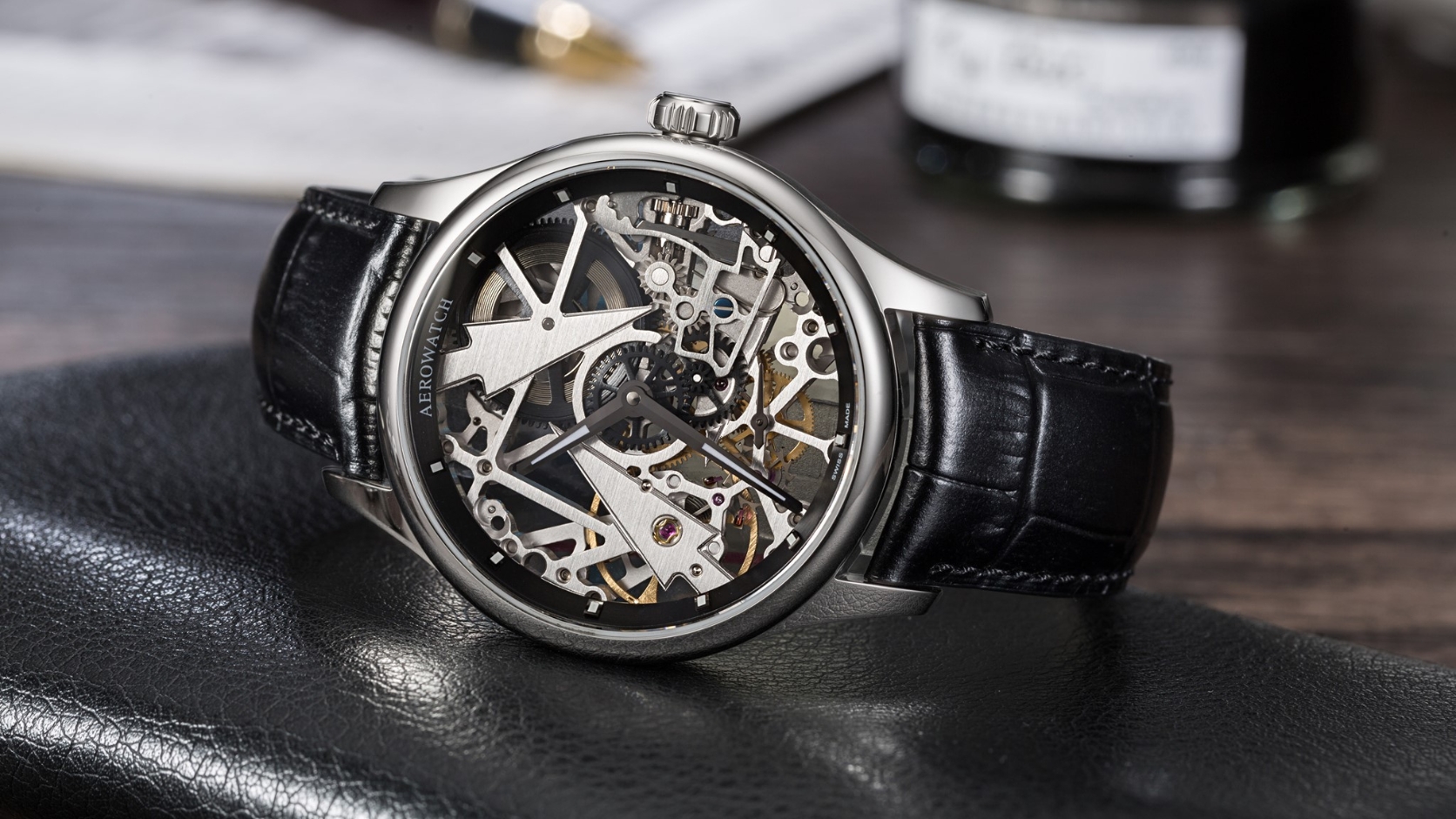 Aerowatch Renaissance 50981-AA12 z ażurową tarczą odsłaniającą mostki i koła mechanizmu, na czarnym pasku skórzanym