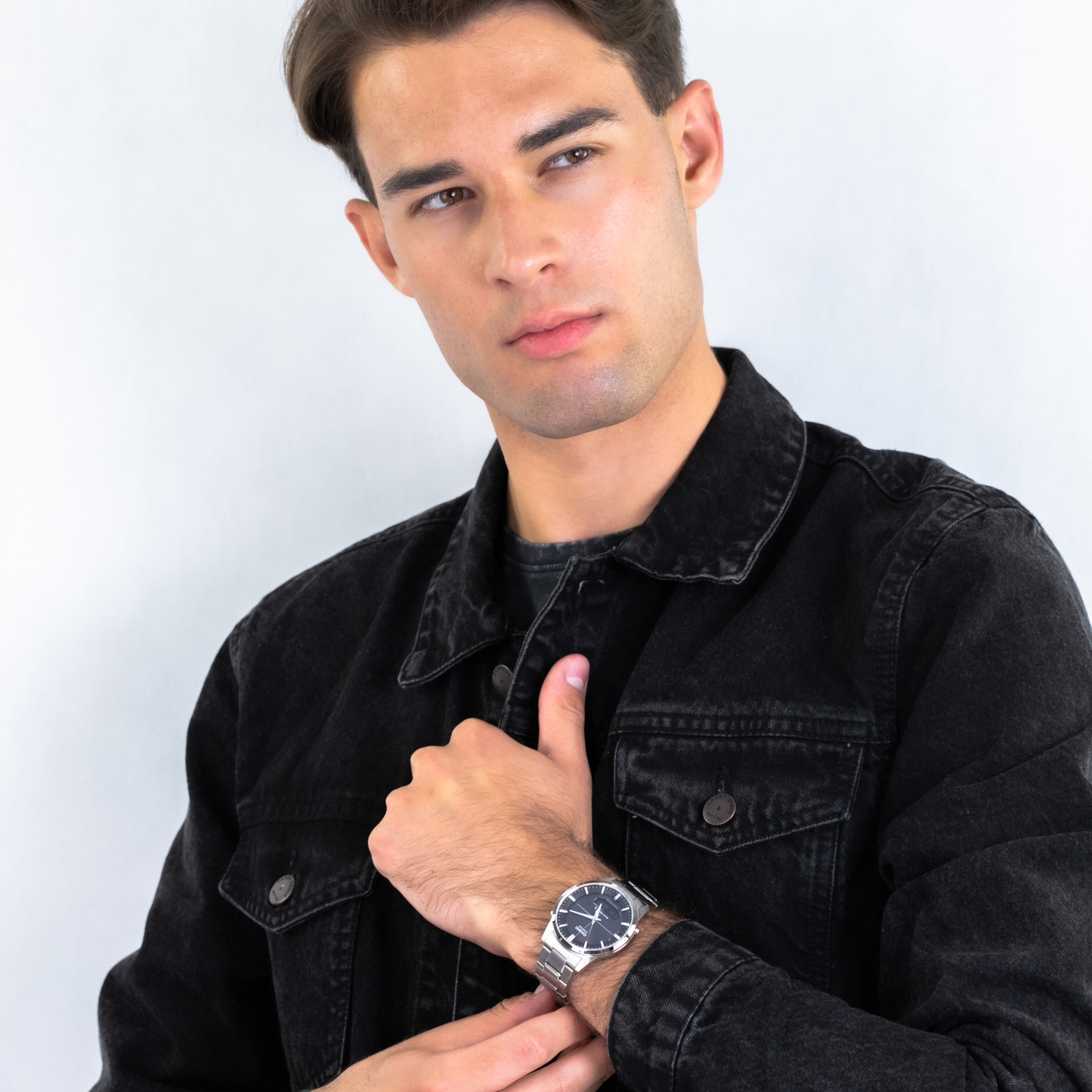 Zegarek z czarną tarczą w okrągłej, srebrnej kopercie na srebrnej bransolecie
