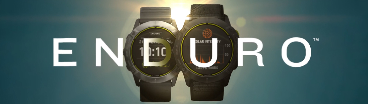 Dwa sportowe zegarki marki Garmin Enduro, umiejscowione po obu stronach loga, na tle wschodzącego słońca.