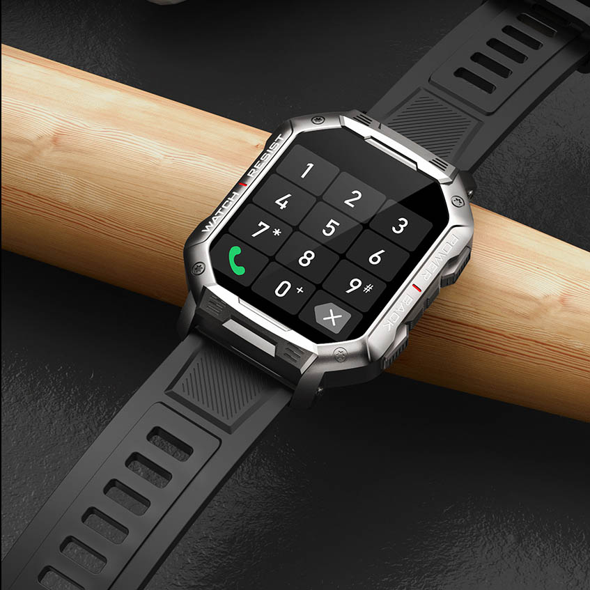 Zdjęcie cyfrowego zegarka smartwatch Hagen HC49 o kwadratowej tarczy, otoczonego metalową obudową, na drewnianym tle.