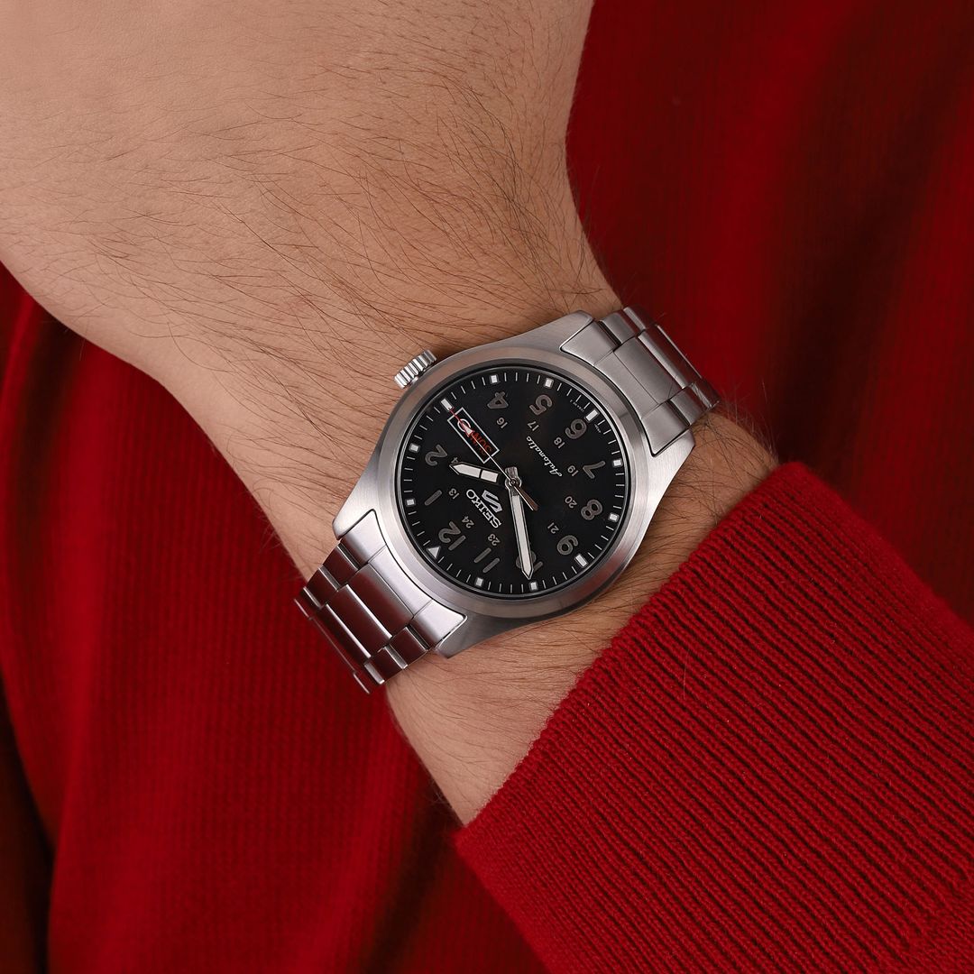 Zegarek Seiko z czarną tarczą oraz wskazówkami pokrytymi Lumibrite w okrągłej kopercie na stalowej bransolecie