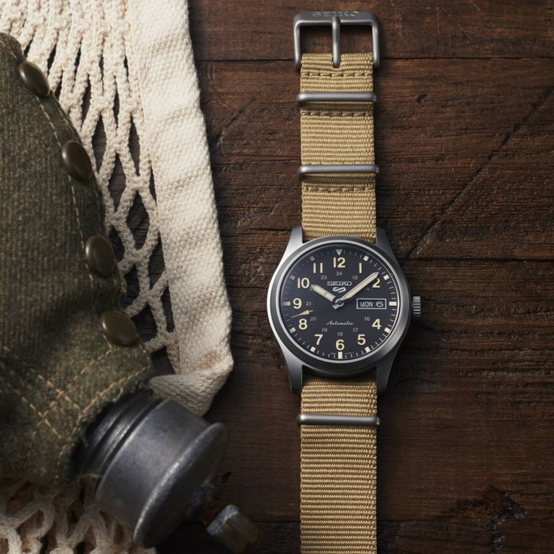 Zegarek Seiko z czarną tarczą w okrągłej, stalowej kopercie na beżowym, materiałowym pasku 