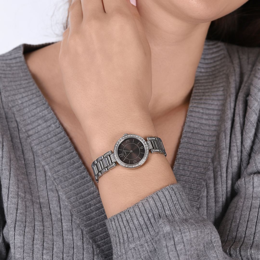 Zegarek Timex z okągłą kopertą z kryształkami oraz ciemną tarczą ze srebrnymi indeksami i wskazówkami