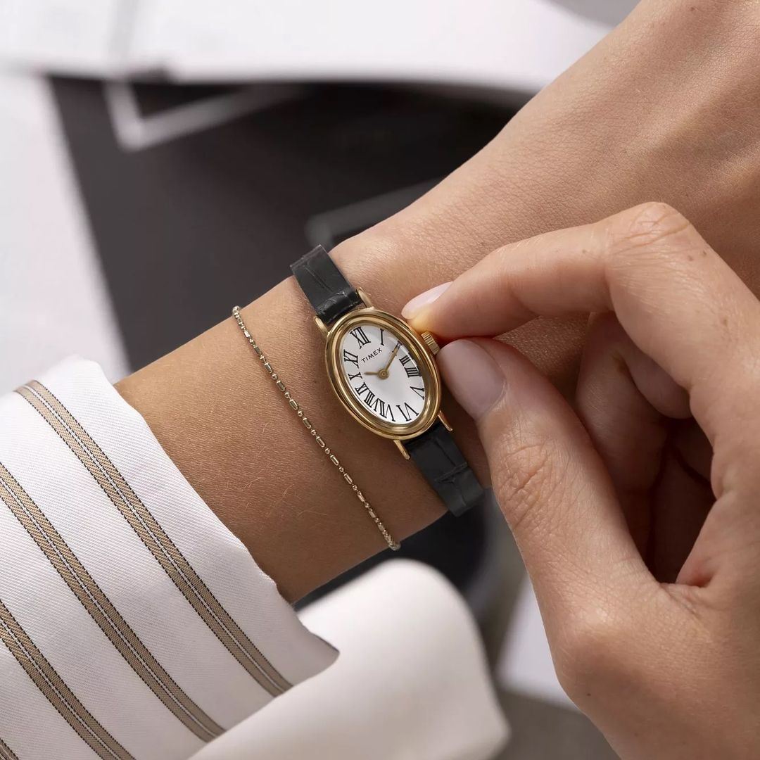 Zegarek damski Timex o smukłej budowie koperty o owalnym kształcie oraz cienkim, czarnym paskiem ze skóry