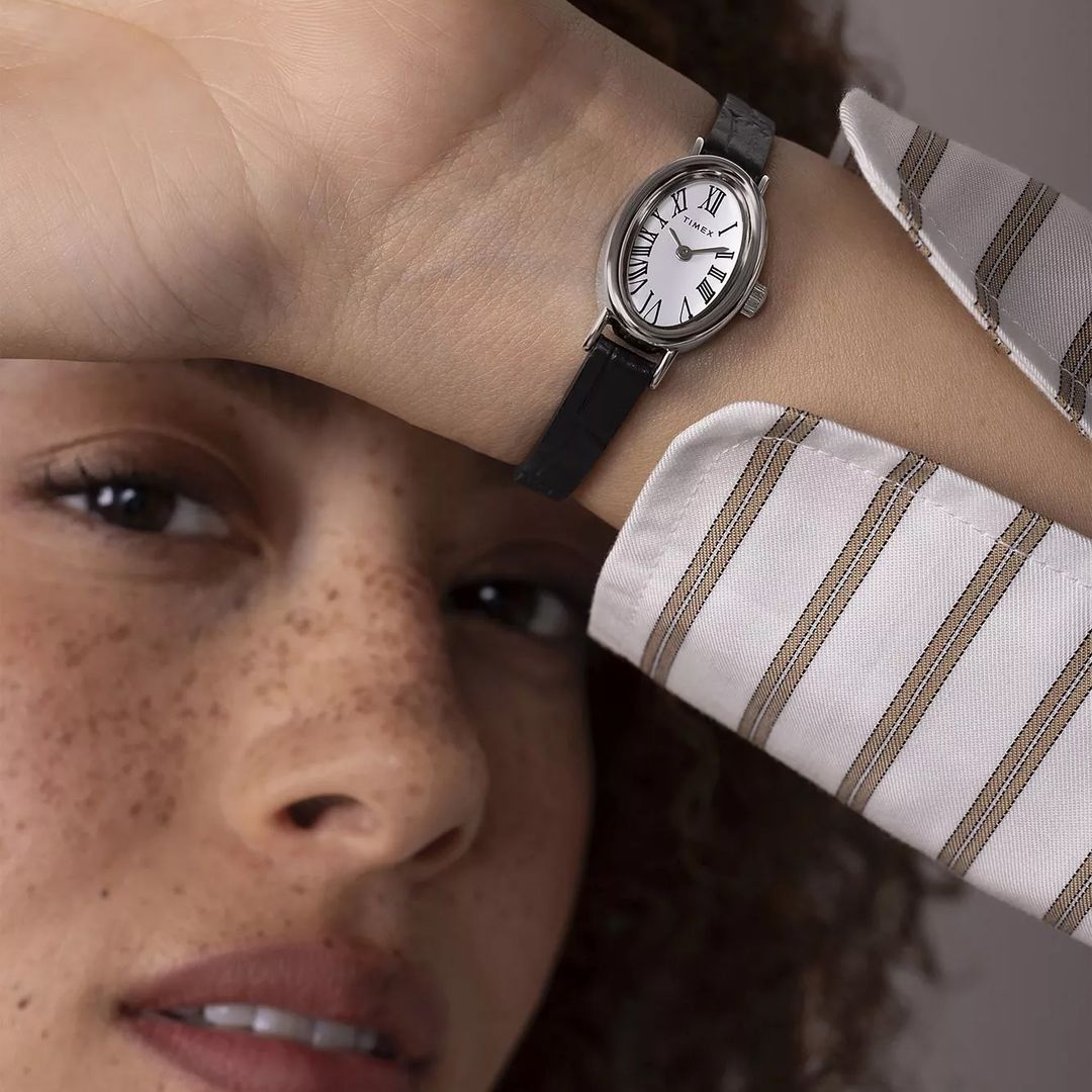 Zegarek damski Timex z niewielką, owalną kopertą w srebrnym kolorze oraz białą tarczą z indeksami rzymskimi