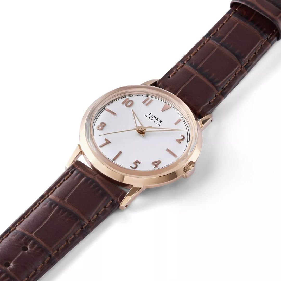 Zegarek Timex z białą tarczą z indeksami i wskazówkami w kolorze różowego złota oraz okrągłą kopertą