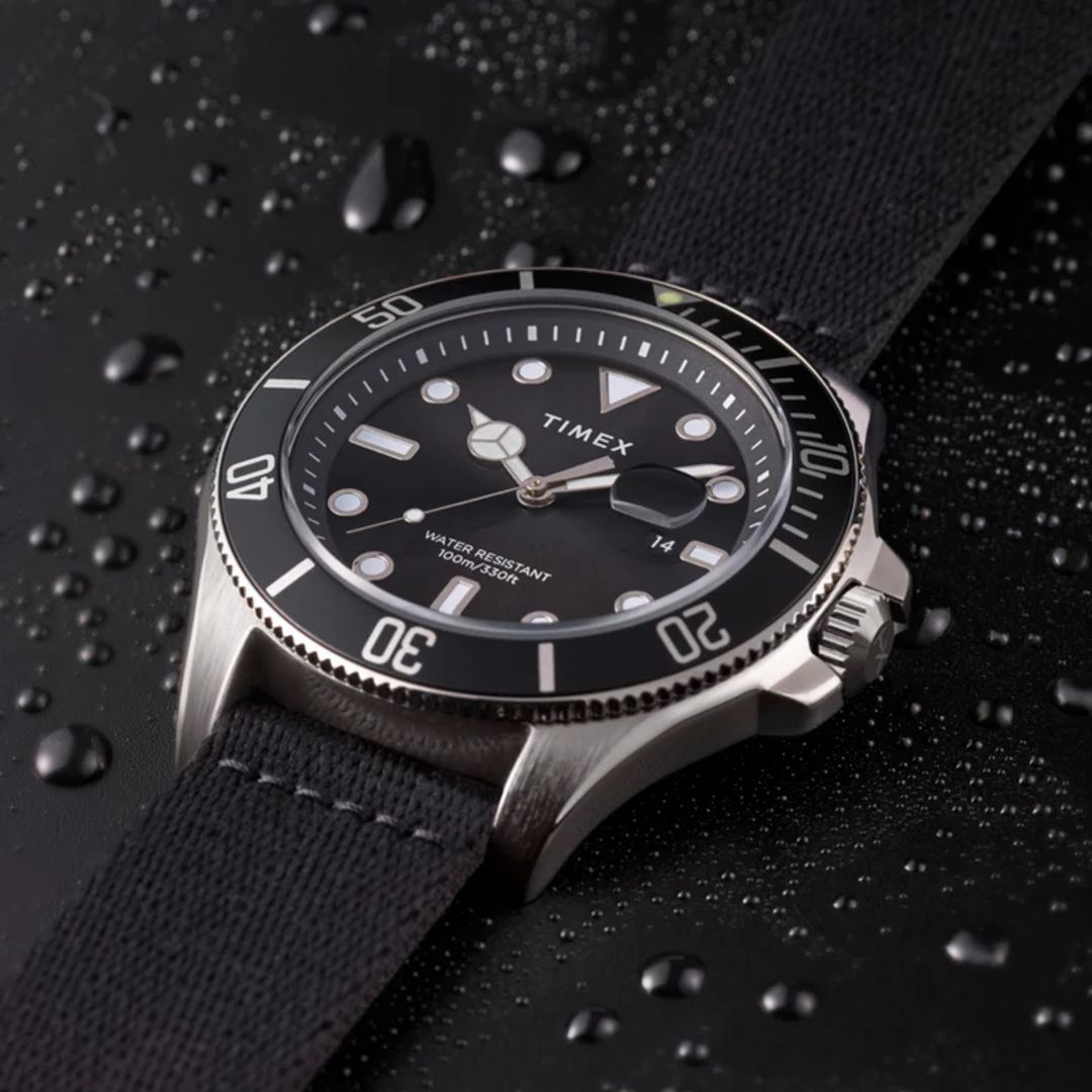 Zegarek Timex z czarną tarczą, czarnym bezelem w okrągłej kopercie w srebrnym kolorze oraz z czarnym paskiem