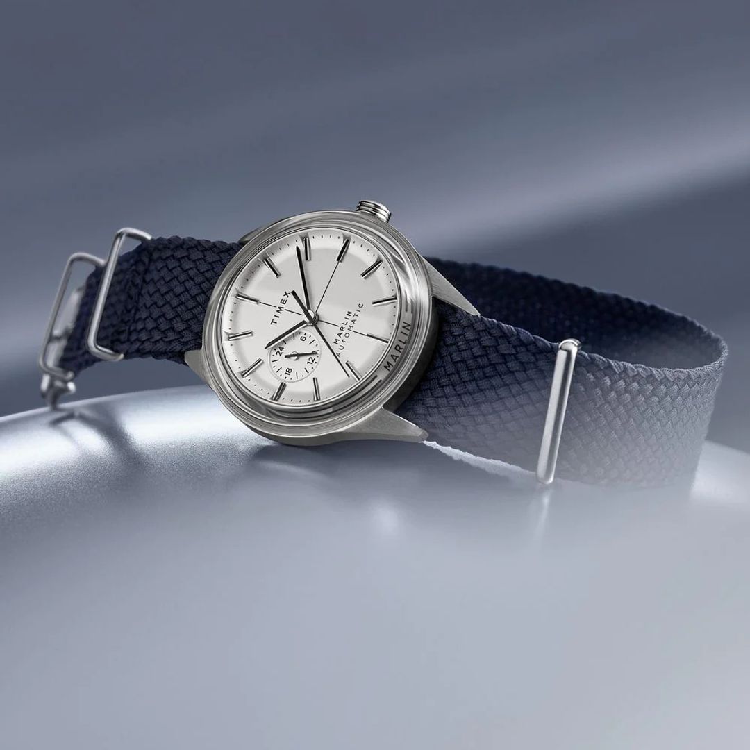 Zegarek Timex z jasną tarczą w okrągłęj, stalowej kopercie na materiałowym, granatowym pasku