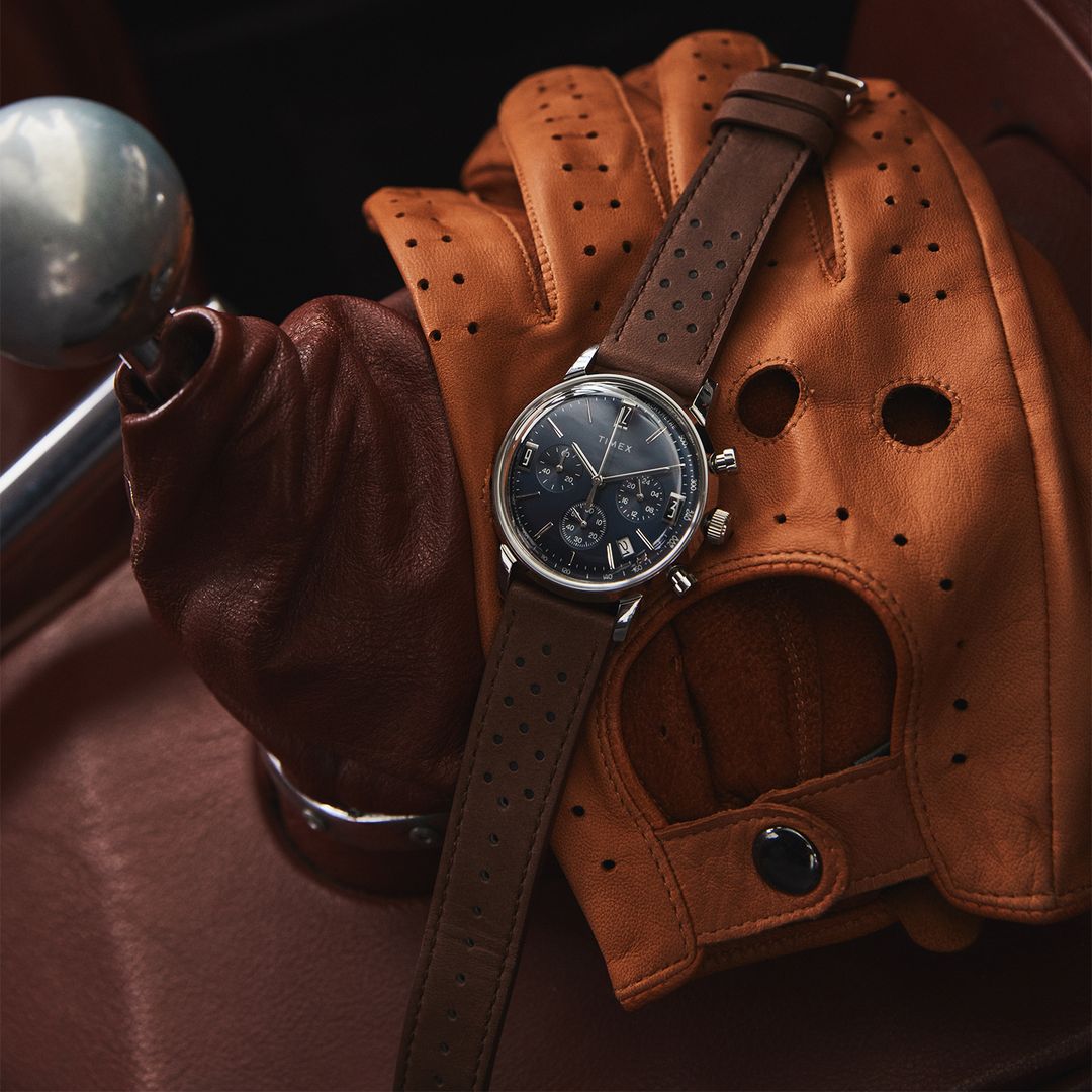 Zegarek Timex z ciemną, granatową tarczą w okrągłej, srebrnej kopercie na brązowym pasku