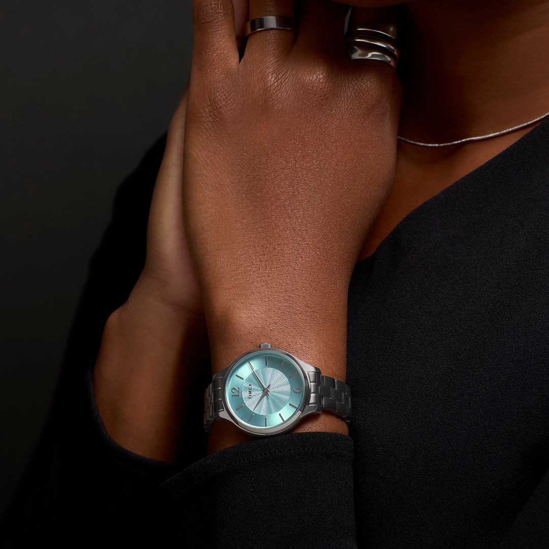 Zegarek marki Timex z jasną, niebieską tarczą oraz okrągłą kopertą w srebrnym kolorze 