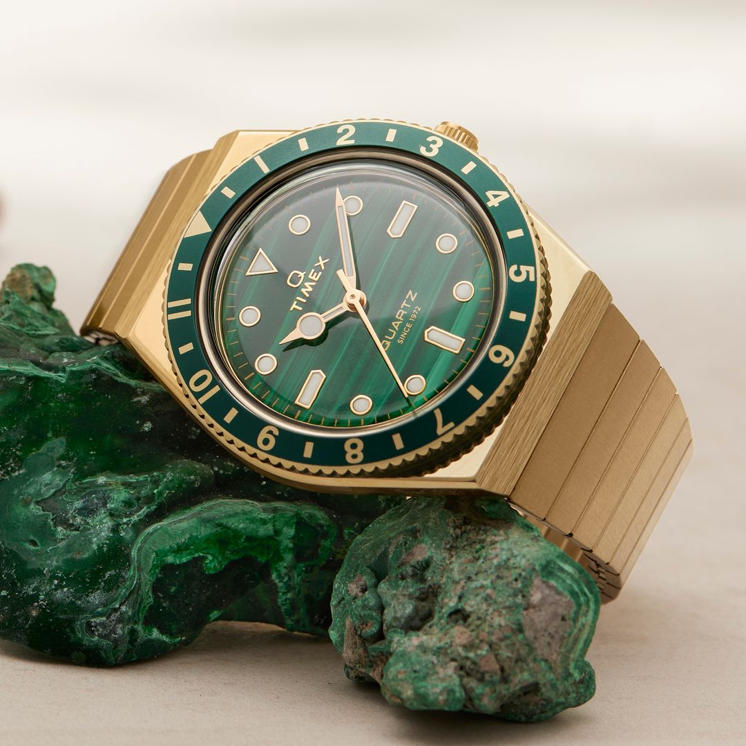 Zegarek Timex z zieloną tarczą i bezelem w zaokrąglonej, złotej kopercie na masywnej bransolecie