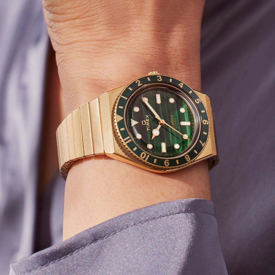 Zegarek Timex z zieloną tarczą w złotej kopercie na złotej bransolecie dopasowującej się do wielkości nadgarstka