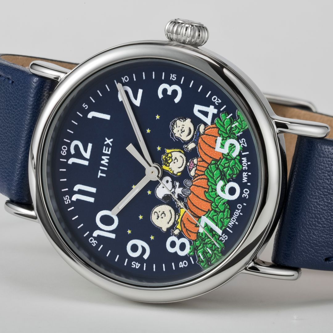 Zegarek Timex z grafiką Snoopy-ego z przyjaciółmi wśród dyń na czarnej tarczy z cyframi arabskimi