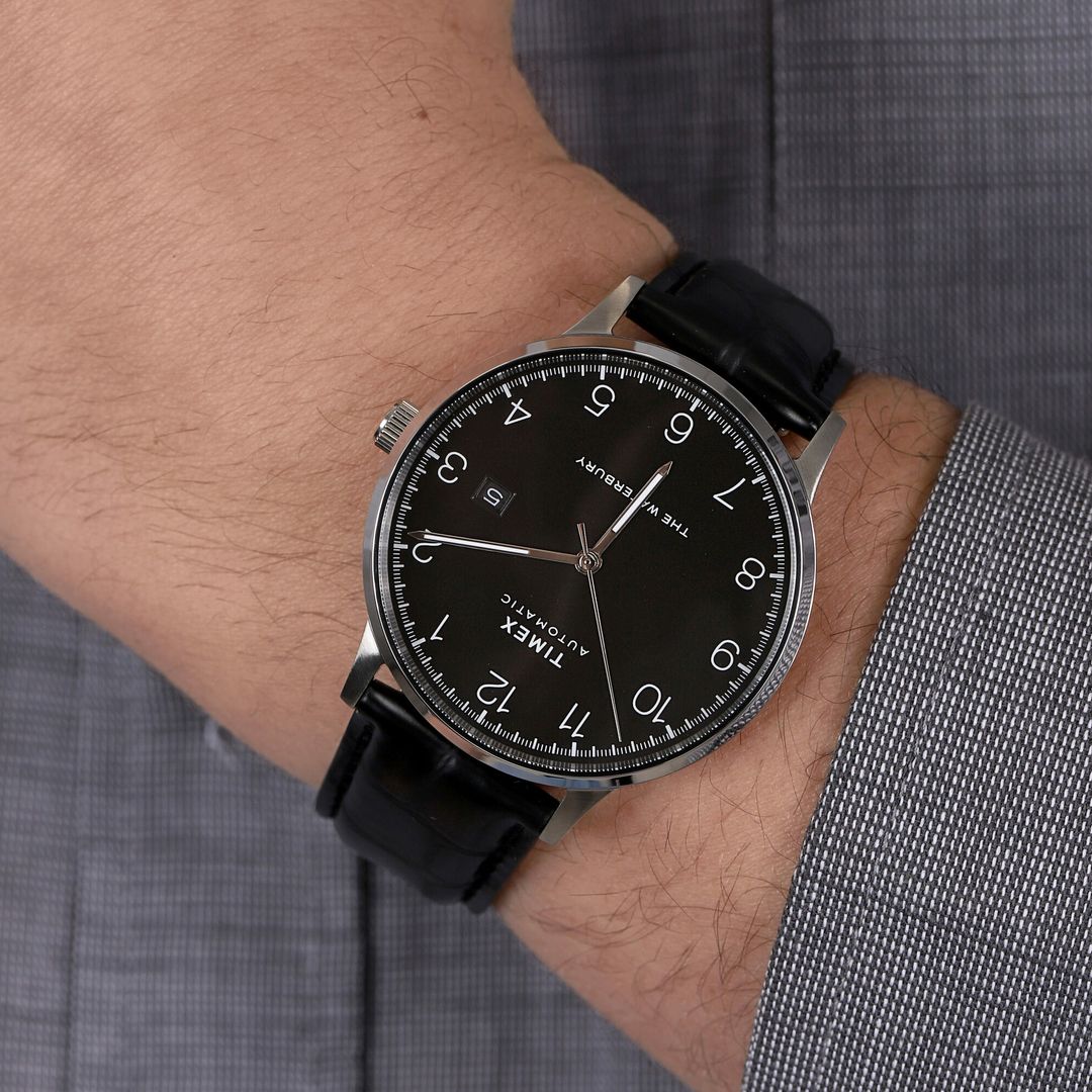 Zegarek Timex z okrągłą, stalową kopertą, czarną tarczą z wyraźnymi, białymi cyframi na czarnym, skórzanym pasku