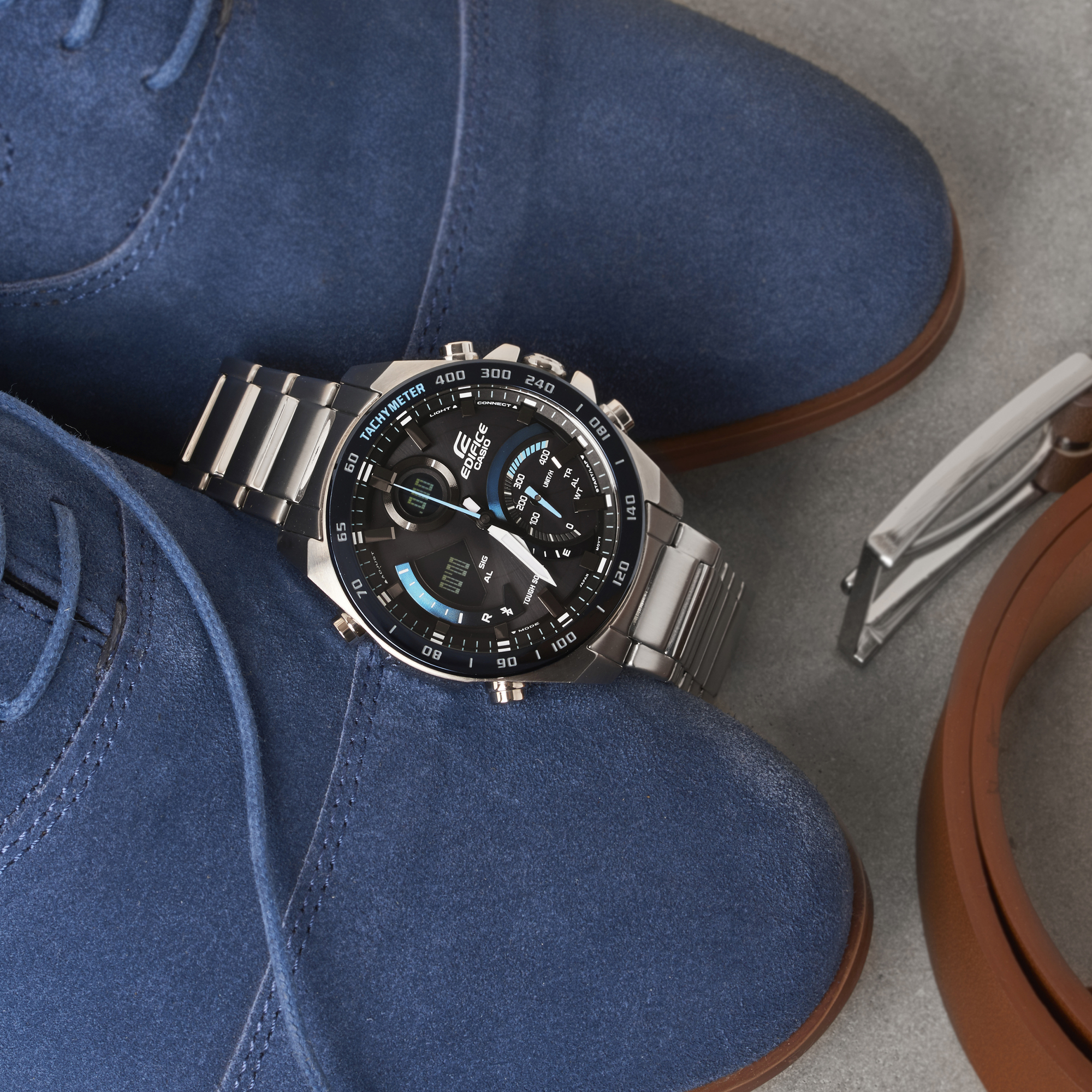 Elegancki zegarek Casio Bluetooth między butami oraz paskiem