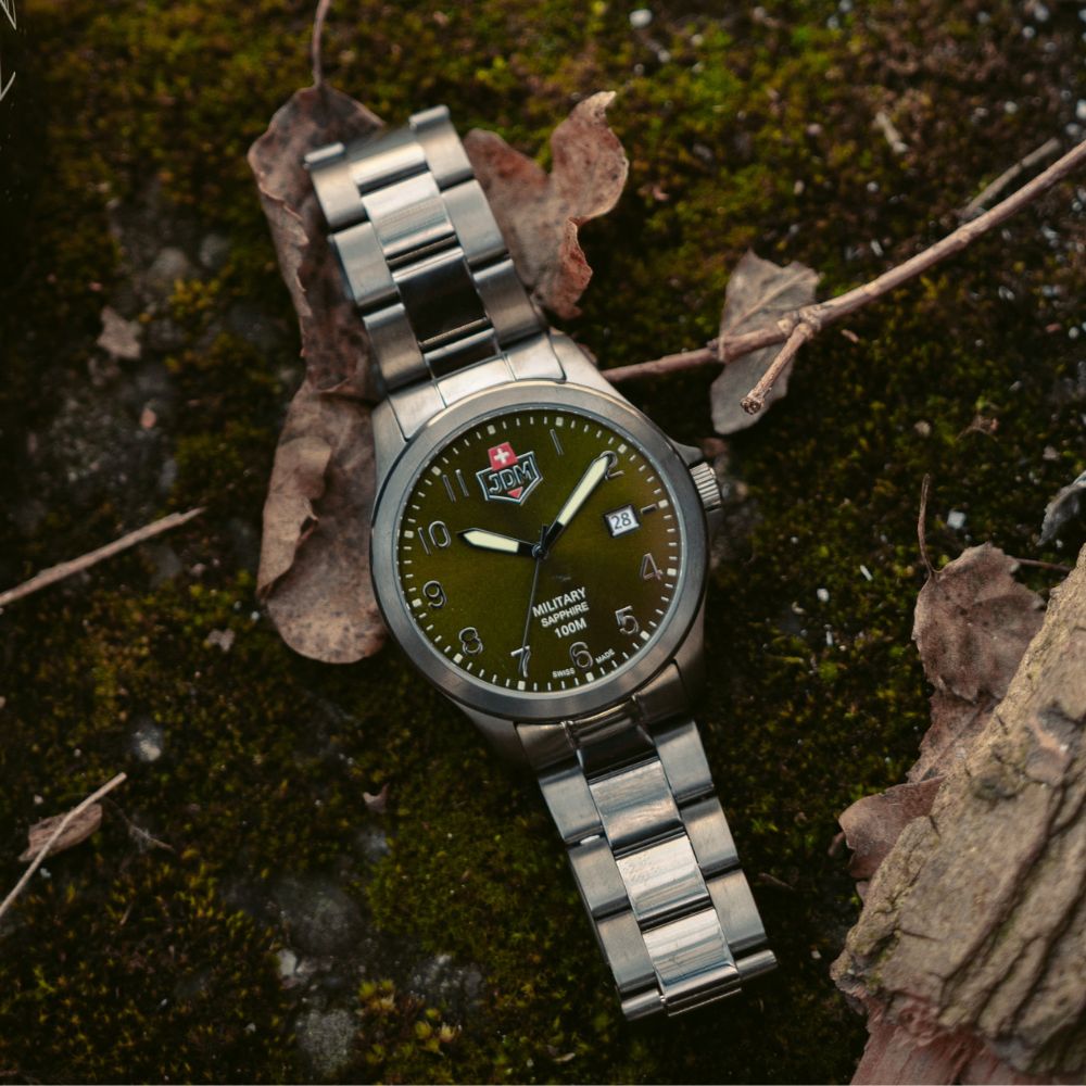 Zegarek JDM Military na bransolecie leżący na ziemi