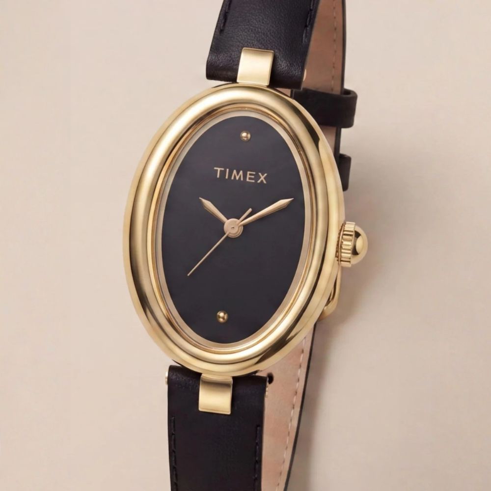Zegarek Timex Cavatina z czarną tarczą i złotą kopertą na beżowym tle