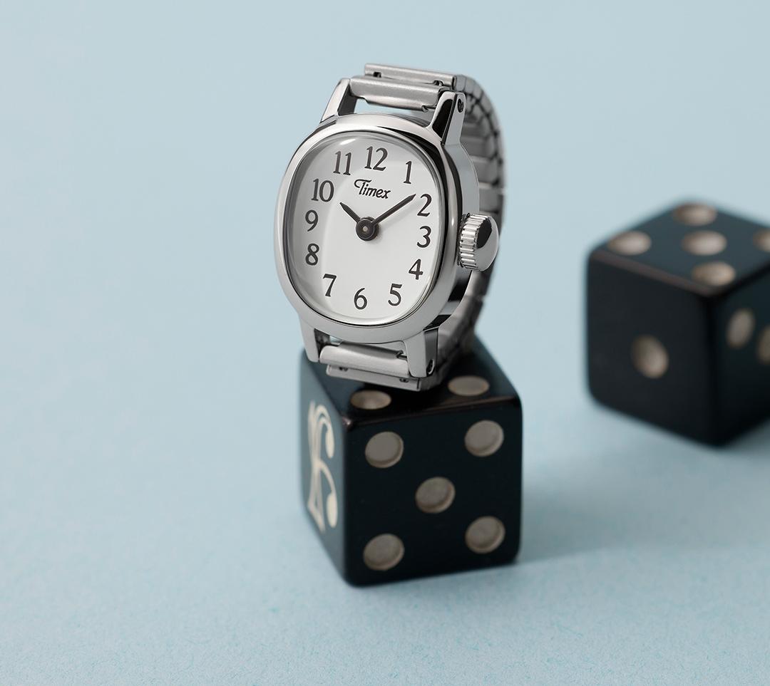 Serbrny zegarek Timex Cavatina w formie pierścionka stojący na kostce do gry